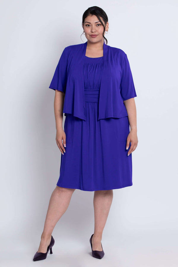 Full body front view of model in cobalt blue short sleeve cropped jacket and dress