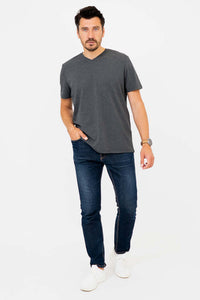Full-body front view of man in dark grey V-neck T-shirt and jeans
