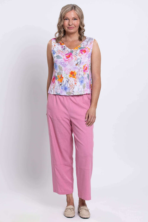 Full body front view of woman in floral cropped tank with pink pants and beige shoes