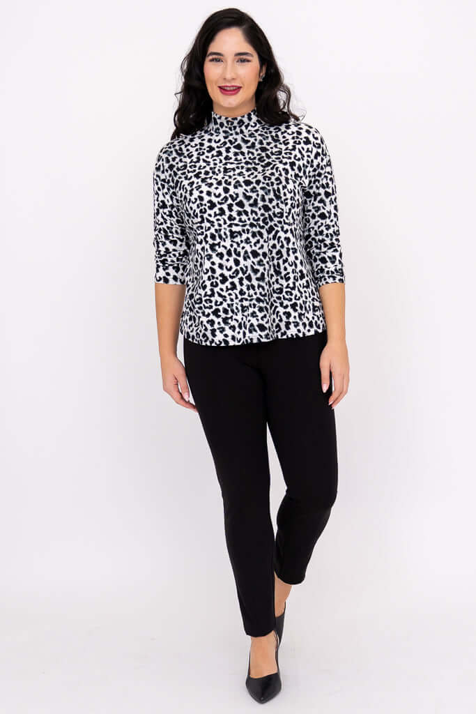 Full body front view of woman in leopard print top and black pants