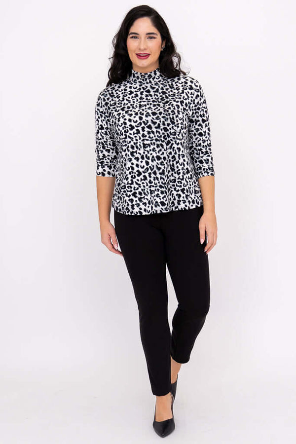 Full body front view of woman in leopard print top and black pants