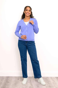 Full body view of model in light purple cardigan and blue jeans, facing forward