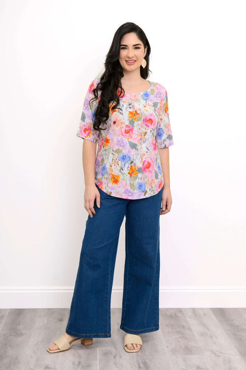 Full body front view of model in Liza floral bamboo linen blouse with blue wide-leg pants