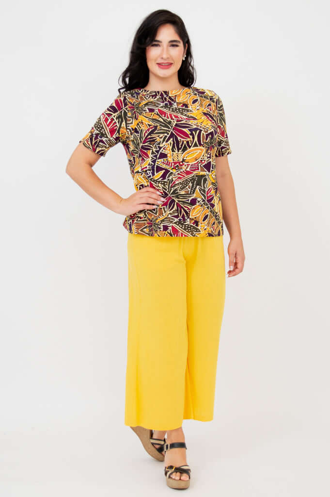 Second model wearing the same botanical print tee and yellow pants, full body, front view