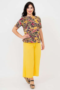 Second model wearing the same botanical print tee and yellow pants, full body, front view