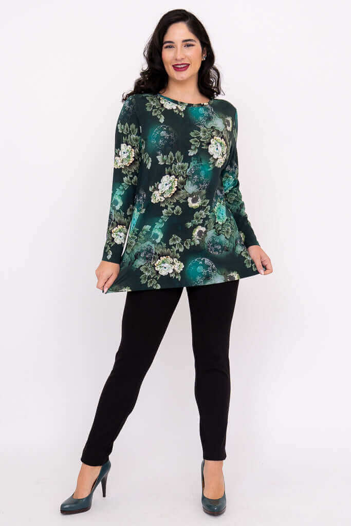 Woman modeling a long sleeve green floral top with black pants and heels, full front view
