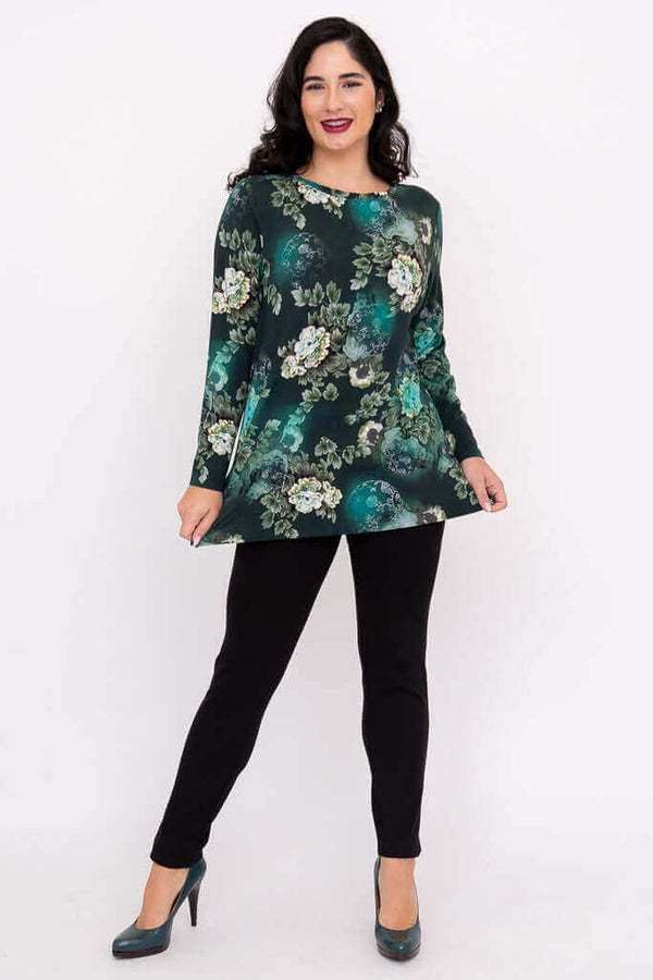 Woman modeling a long sleeve green floral top with black pants and heels, full front view