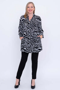 Full body view of woman in zebra print tunic shirt with hands in pockets