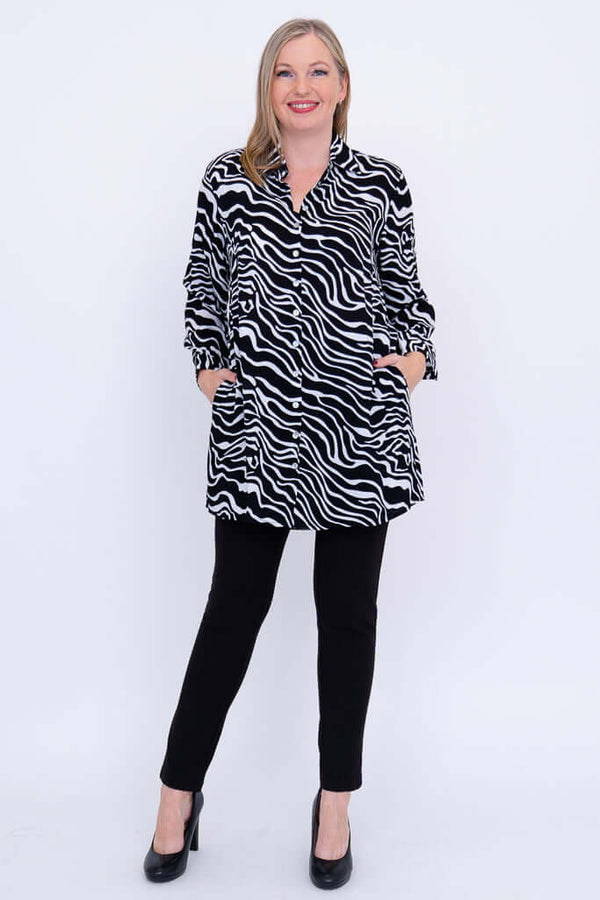 Full body view of woman in zebra print tunic shirt with hands in pockets