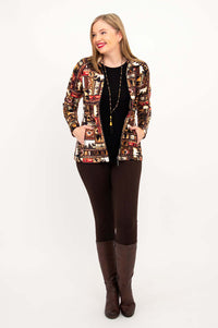 Woman in full outfit modeling patterned Sona jacket, black top, brown leggings, and tall boots