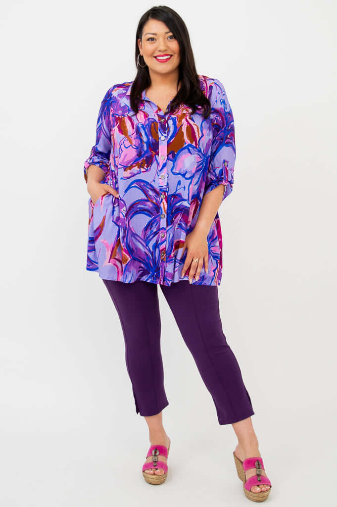 Full-length view of model in purple floral tunic, paired with purple capri pants and pink sandals