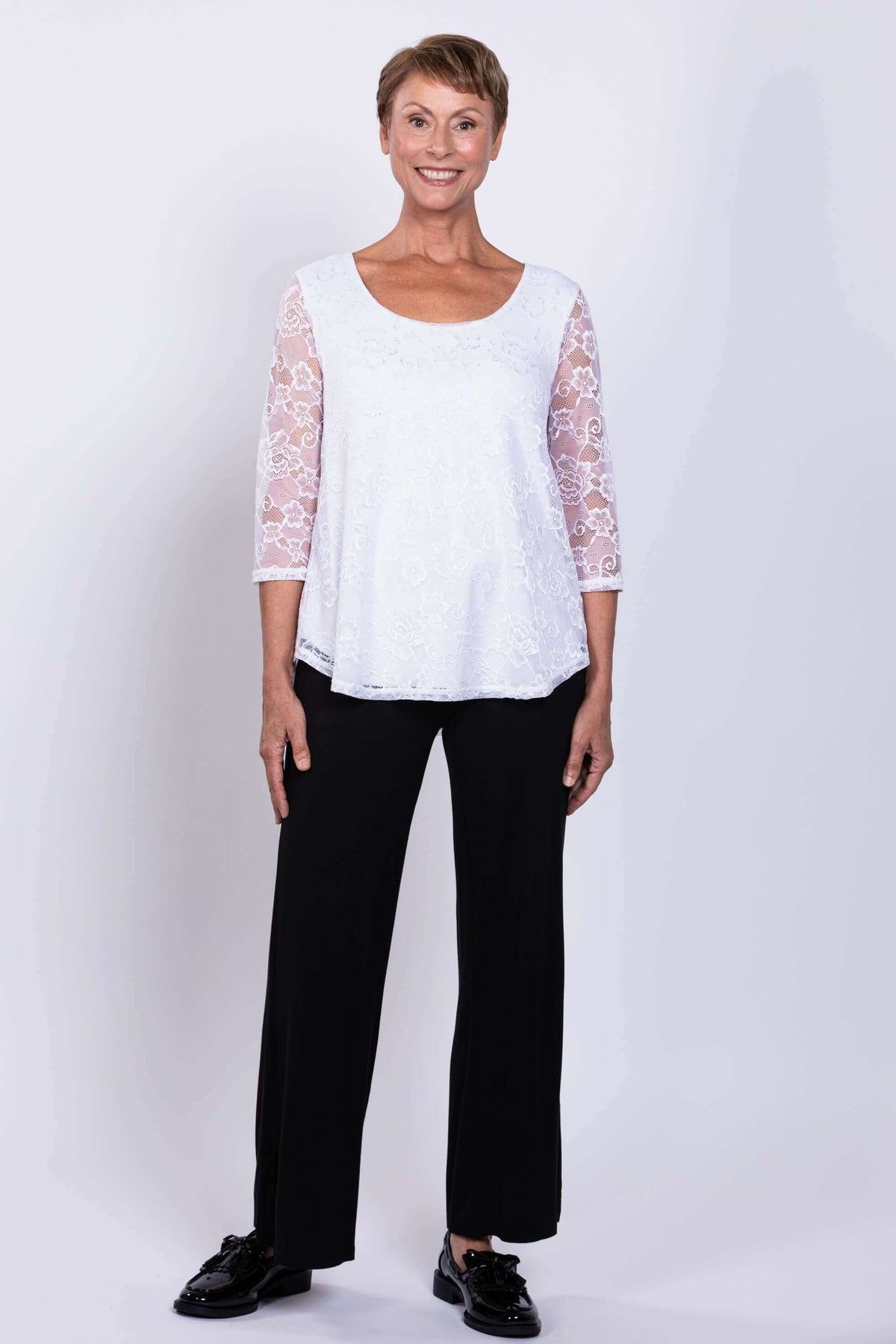 Full body view of model in white lace Ellen Top and black pants