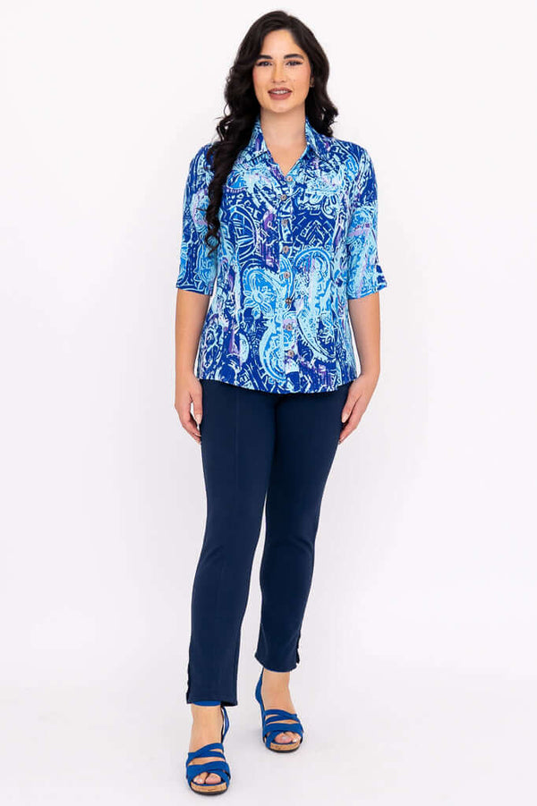 Full body view of a woman modeling a blue printed blouse and navy pants