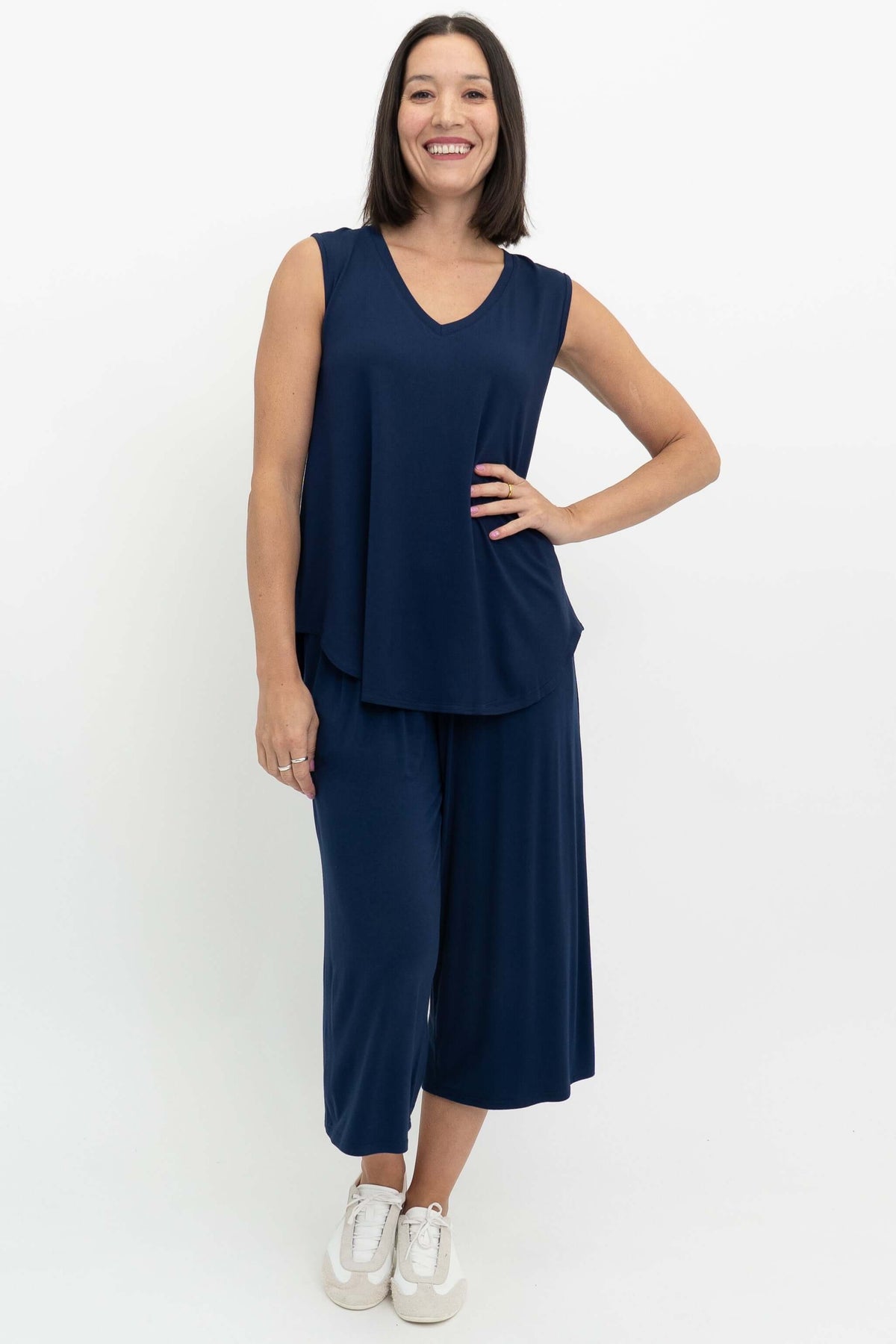 Full body view of woman in navy blue sleeveless V-neck top and matching pants