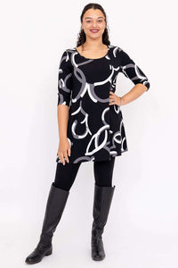 Full body view of model in Spirit Dress with black boots and leggings, featuring bold abstract print