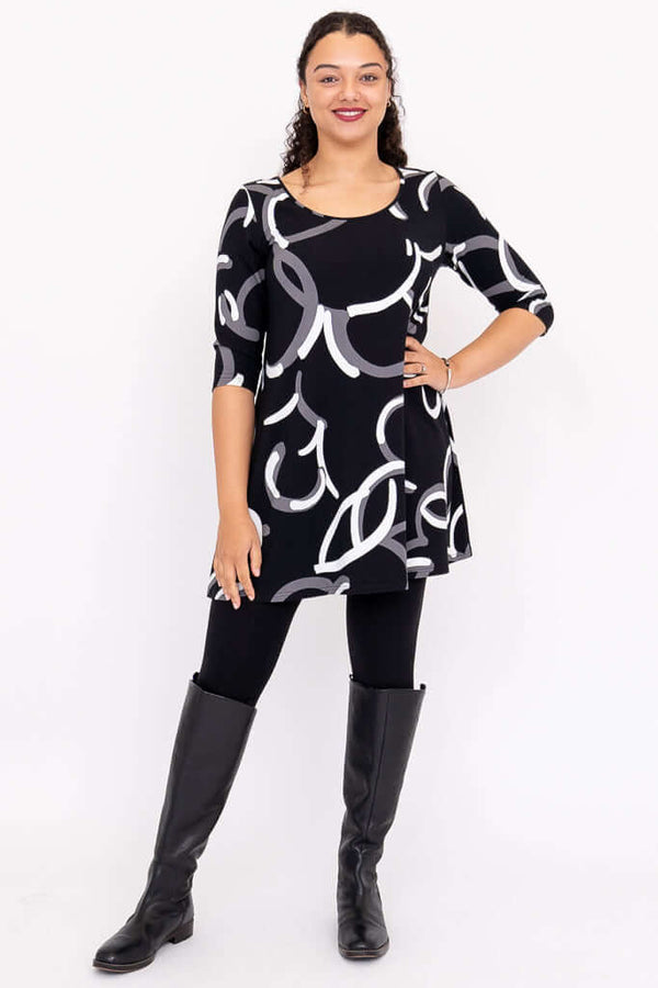 Full body view of model in Spirit Dress with black boots and leggings, featuring bold abstract print