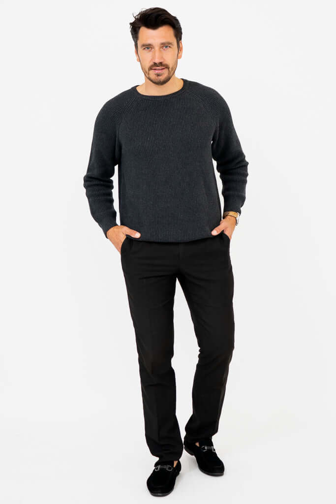 Man standing with hands in pockets, showcasing charcoal ribbed sweater