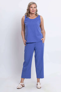 Full body shot of model in blue tank top and matching pants with white sandals