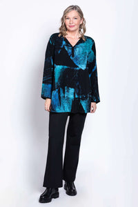 Full body view of model in blue and black batik blouse paired with black pants