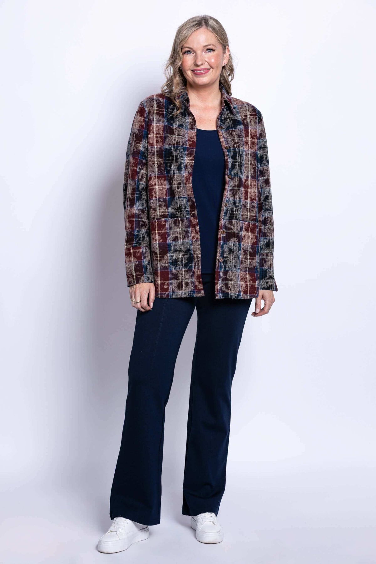 Full body shot of a woman in a plaid button-front cotton jacket and navy pants