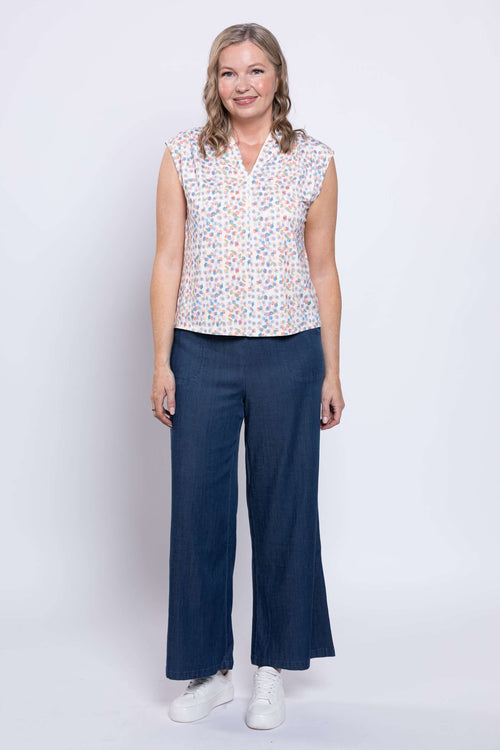 Full body view of woman in Paula Top and wide-leg blue pants, facing forward