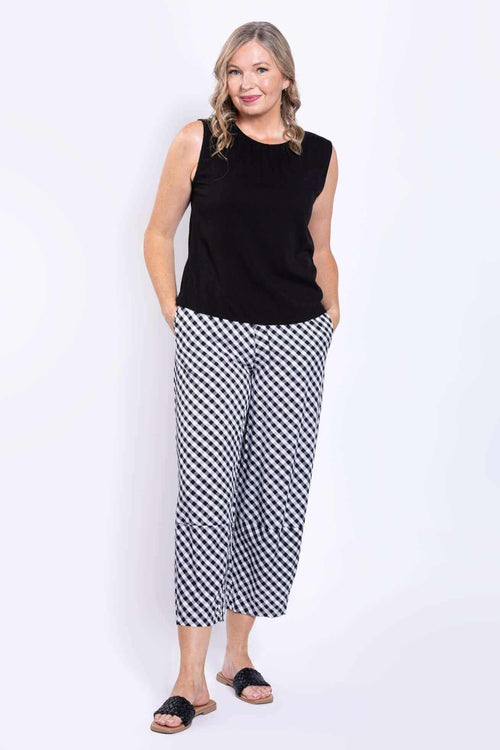 Full body view of woman in black tank top and gingham pants