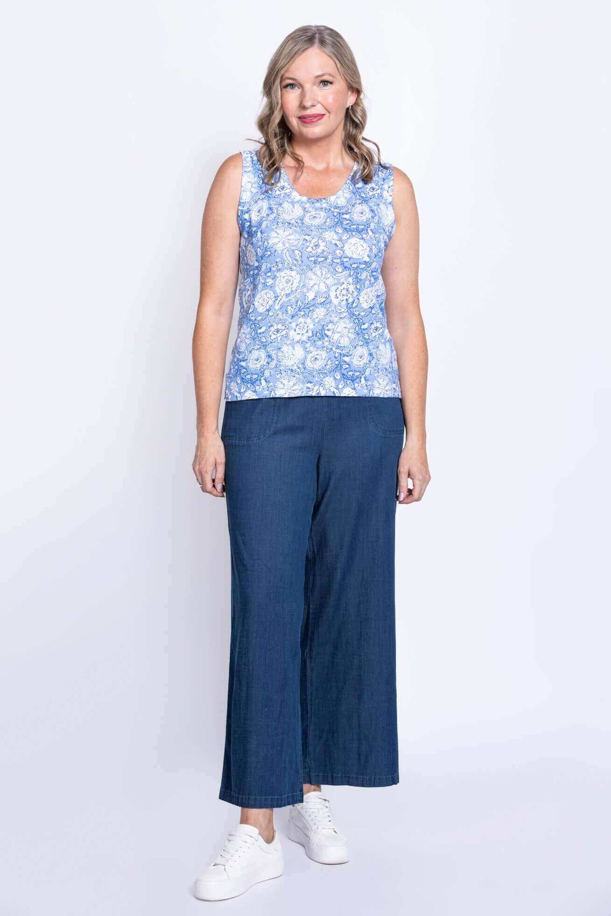 Full body front view of woman in Melanie blue floral tank top with wide-leg pants