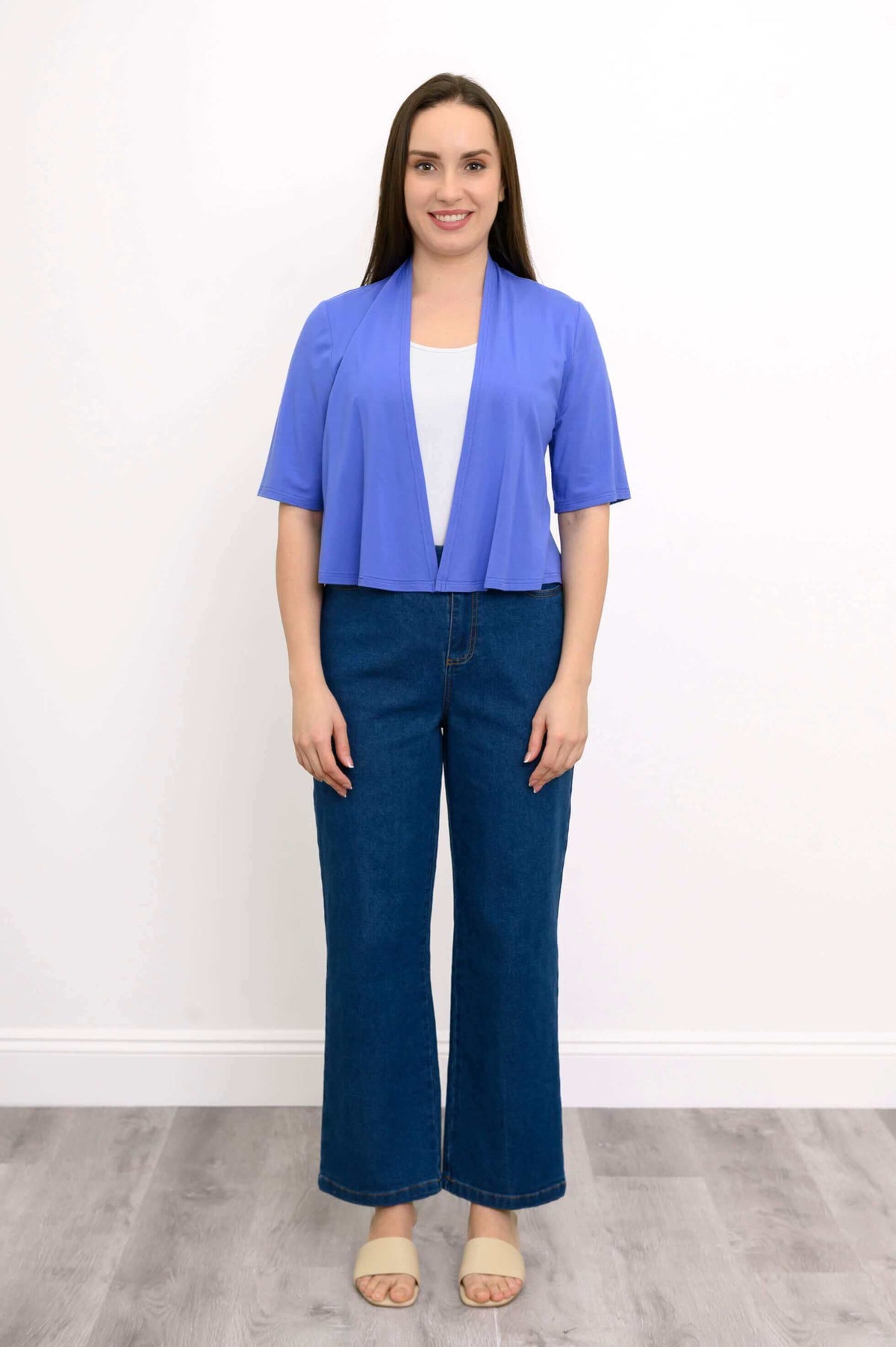 Full body view of woman modeling blue cropped short sleeve open front bamboo jacket