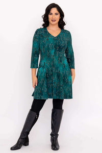 Full body view of woman in teal abstract Wilma Tunic, styled with black leggings and boots