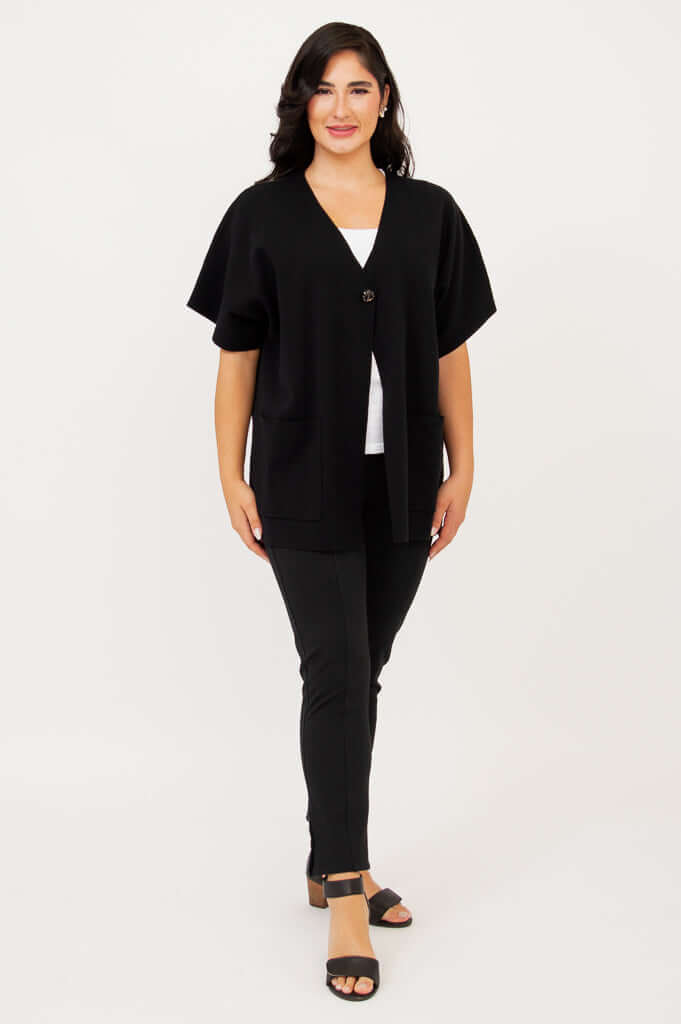 Full body front view of woman modeling a black cardigan with relaxed fit and single button closure