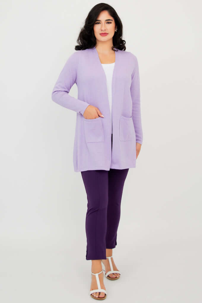 Full body view of woman in light purple open front cardigan, white top, and dark purple pants
