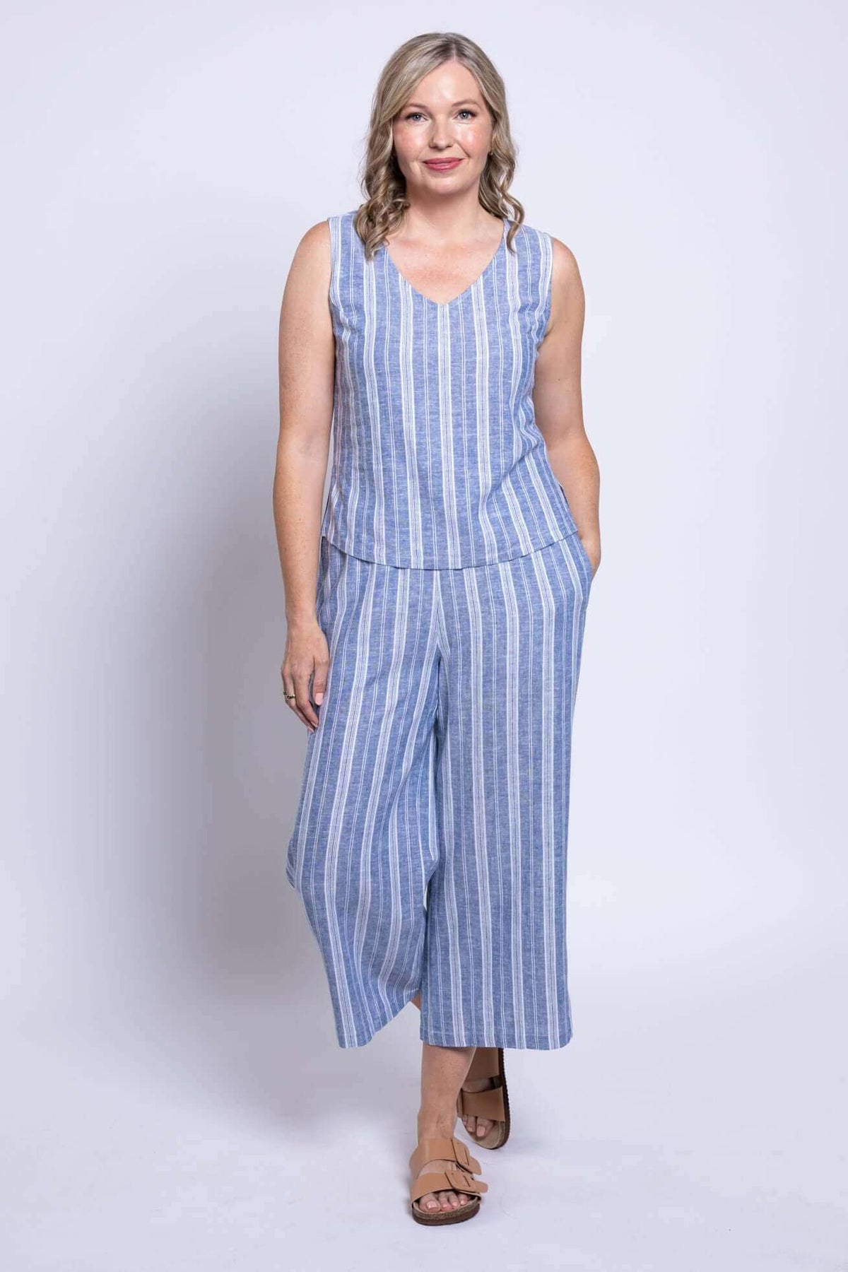 Full body view of woman in blue and white striped sleeveless tank and matching pants