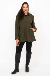 Full body view of woman modeling olive green wool coat with black pants and boots
