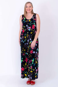 Full front view of a woman in sleeveless floral bamboo maxi dress and red sandals