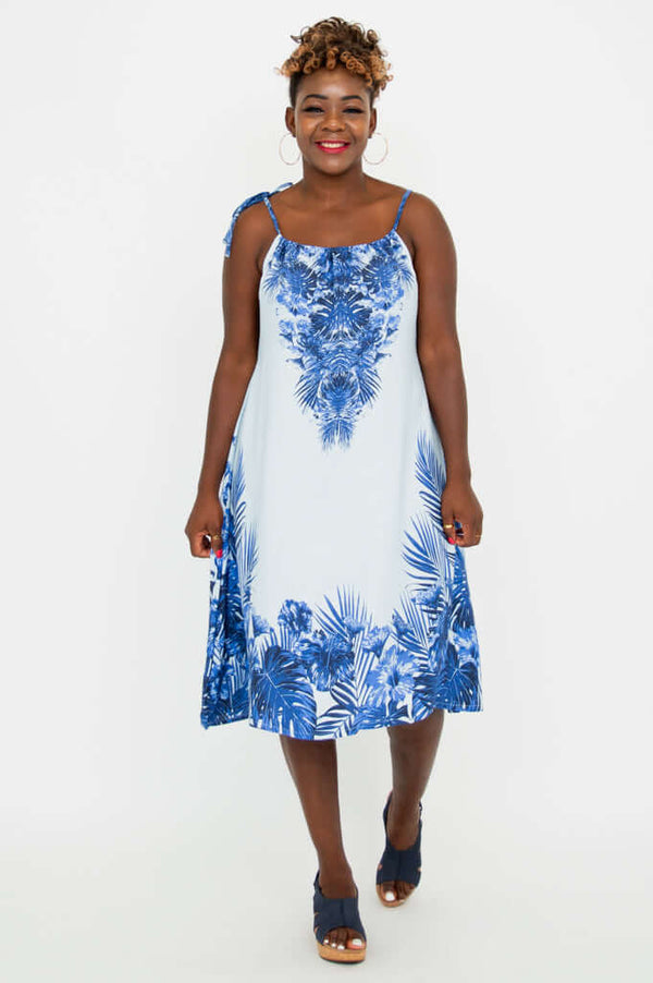 Woman smiling in blue palm print dress, straight-on pose