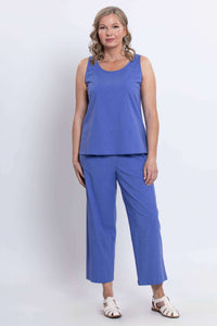 Woman modeling blue sleeveless top and cropped pants, standing front facing