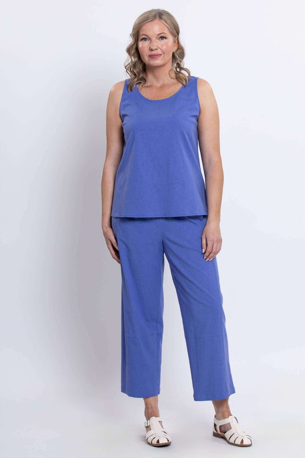 Woman modeling blue sleeveless top and cropped pants, standing front facing