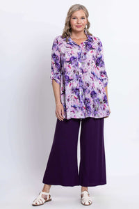Full front view of model in floral tunic with purple wide-leg pants