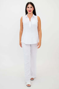 Woman standing front-facing in white tank top and pants