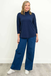 Full front view of woman modeling navy mock neck bamboo top and wide-leg jeans
