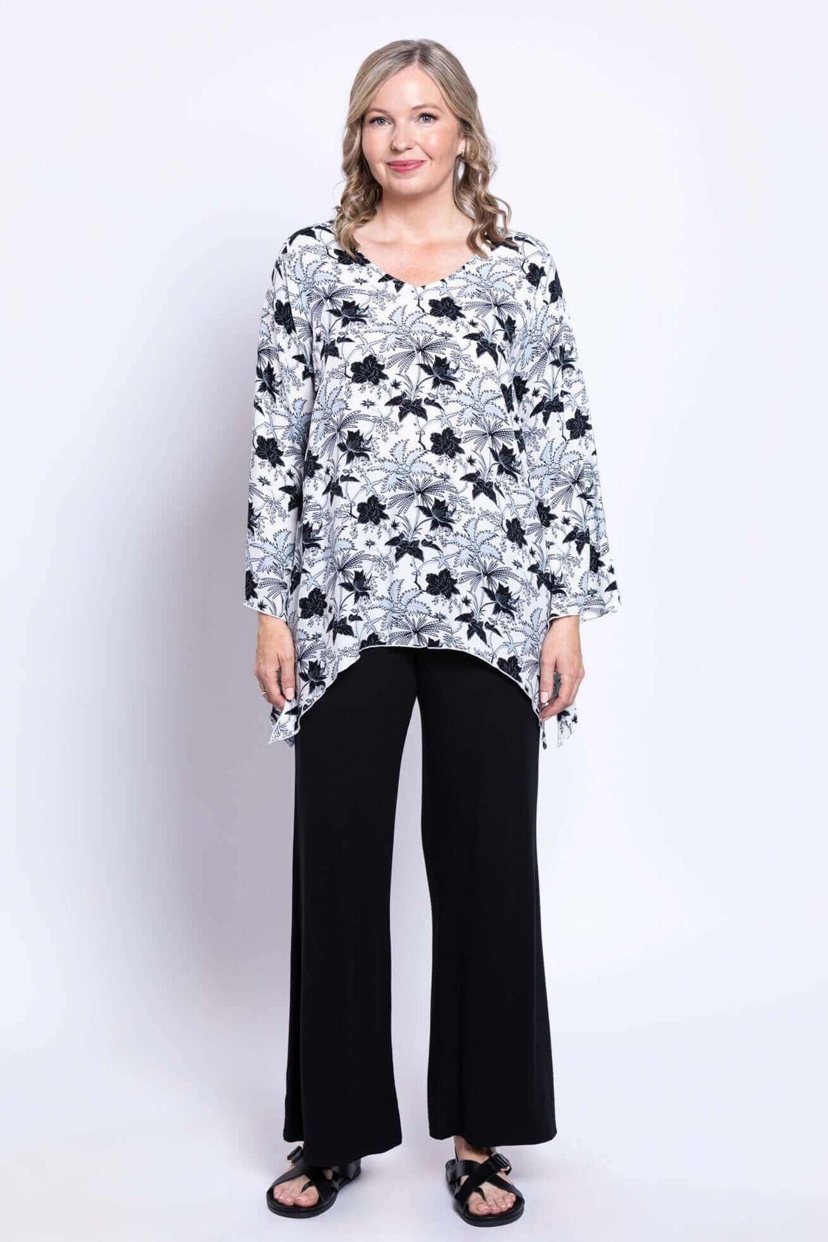 Full front view of model in floral bohemian top and wide-leg black pants