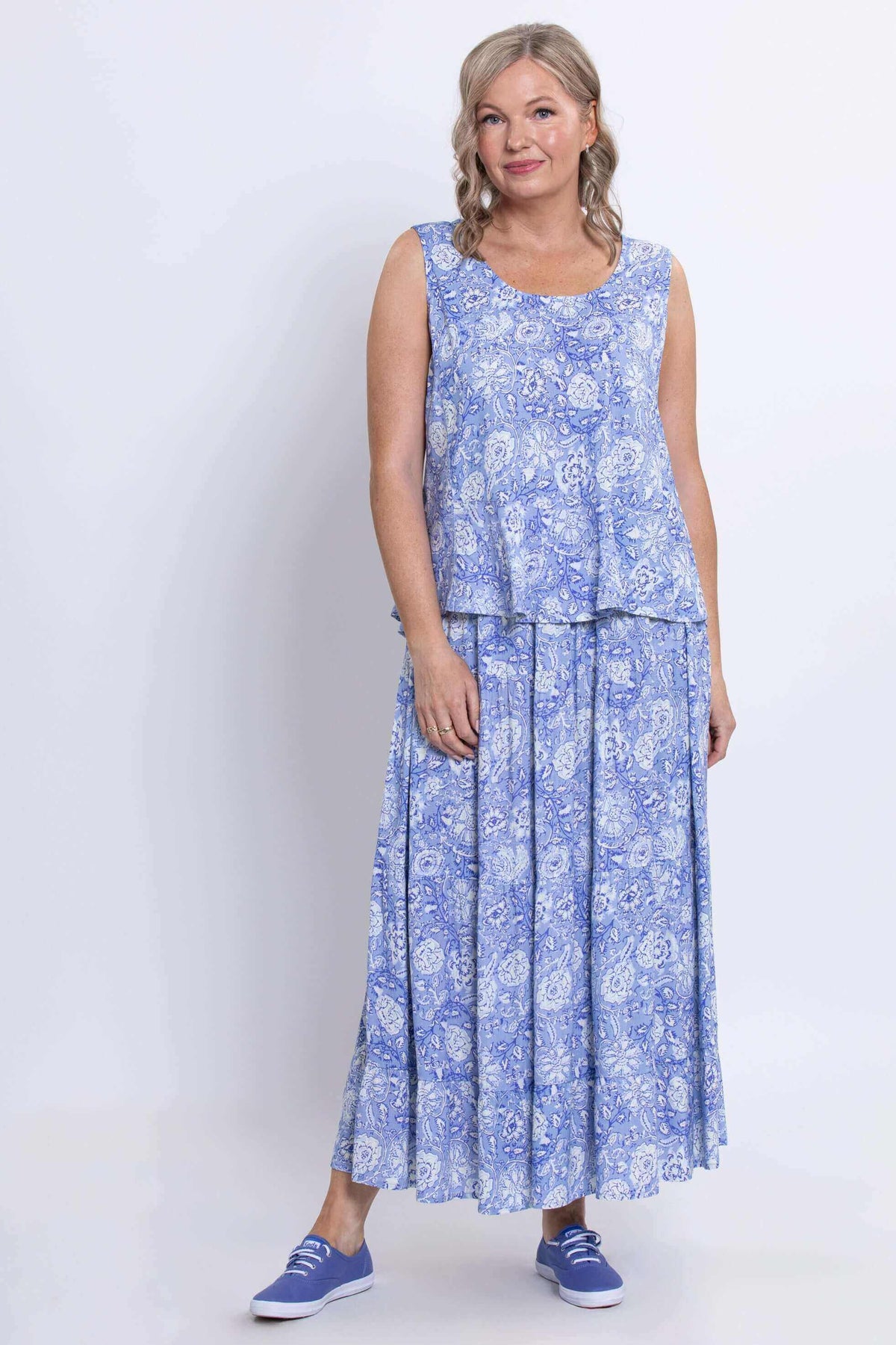 Full front view of woman wearing blue floral Ginny tank top and skirt