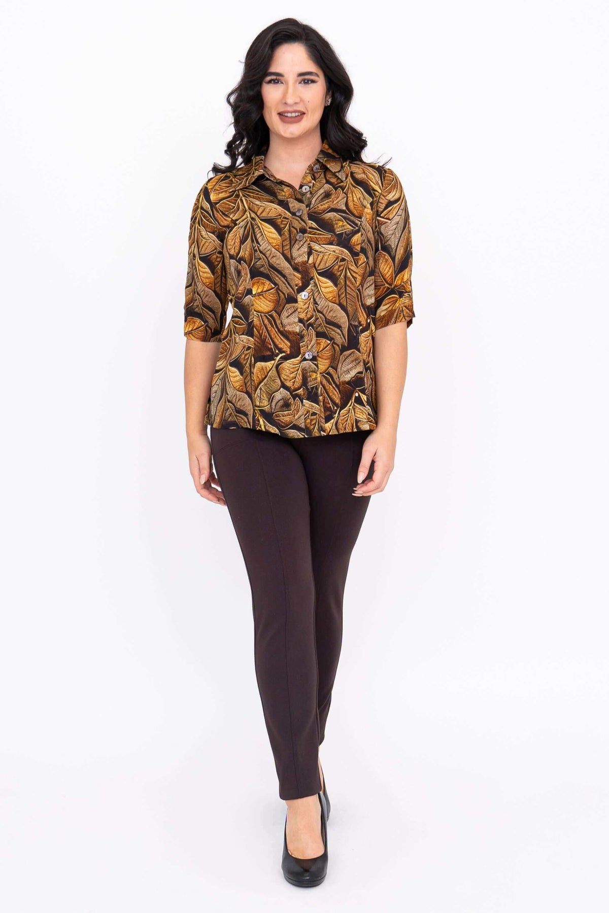 Full front view of model in golden leaf blouse and brown skinny pants