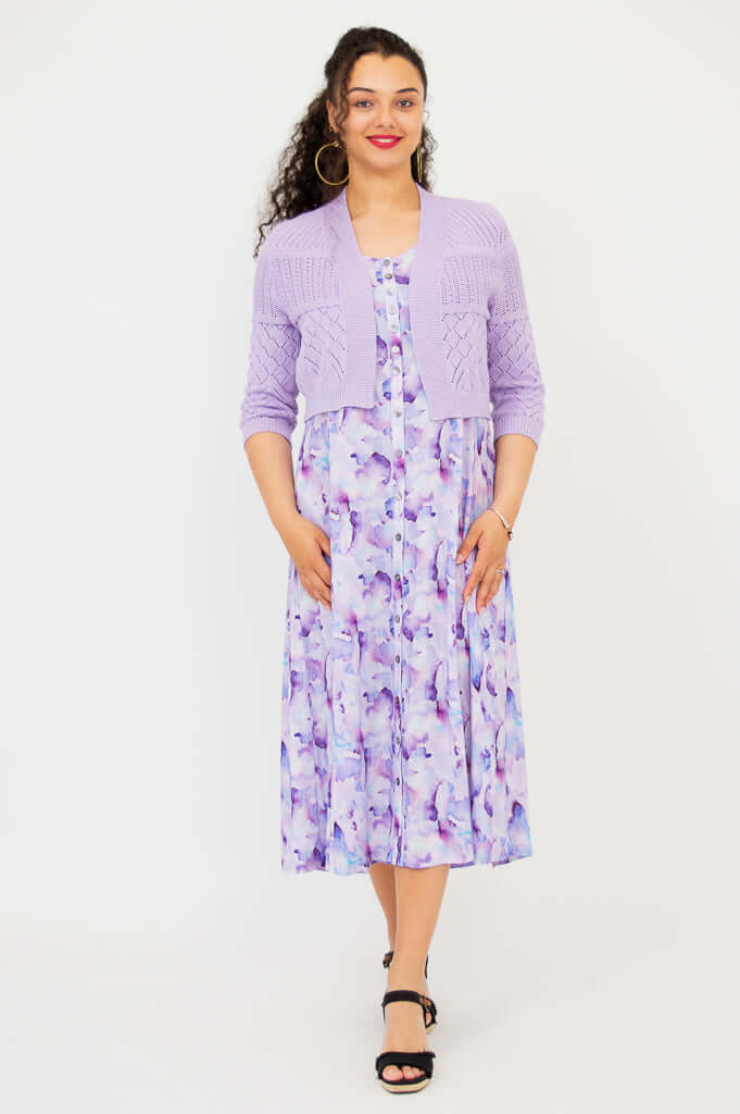 Full front view of woman in lilac cropped cardigan and watercolor dress