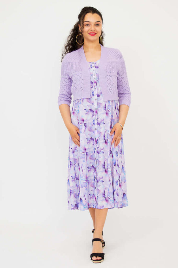 Full front view of woman in lilac cropped cardigan and watercolor dress