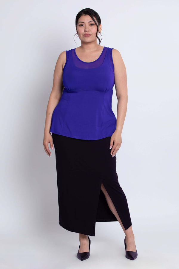 Full front view of model in purple tank top paired with black skirt and heels