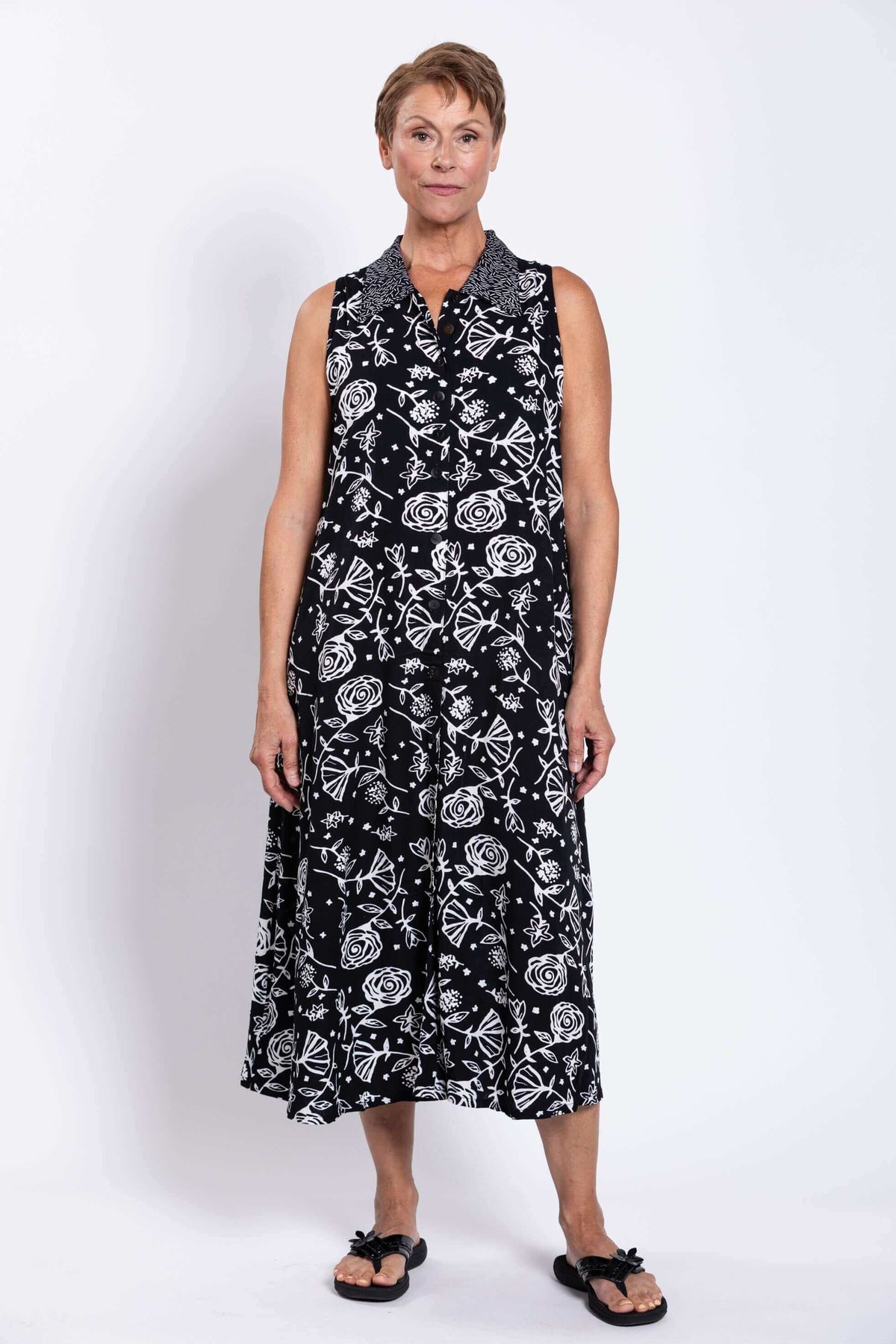Full front view of sleeveless black and white patterned A-line dress on model