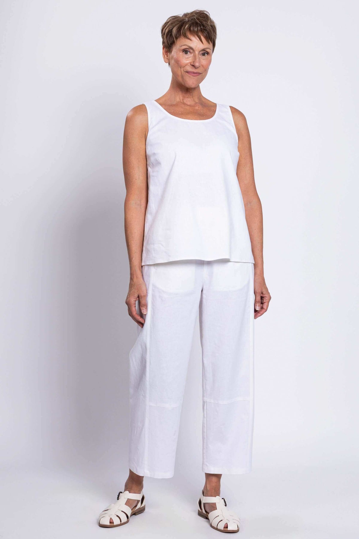 Full front view of woman in white sleeveless linen tank and matching pants