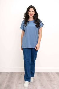 Full front view of woman in blue dolman tee and jeans