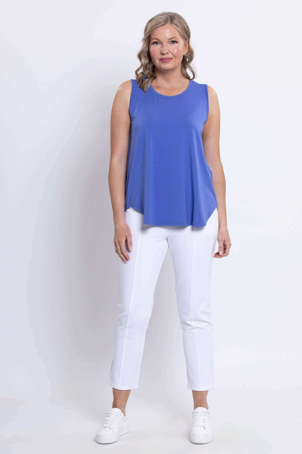 Full front view of woman in blue tank top and white pants